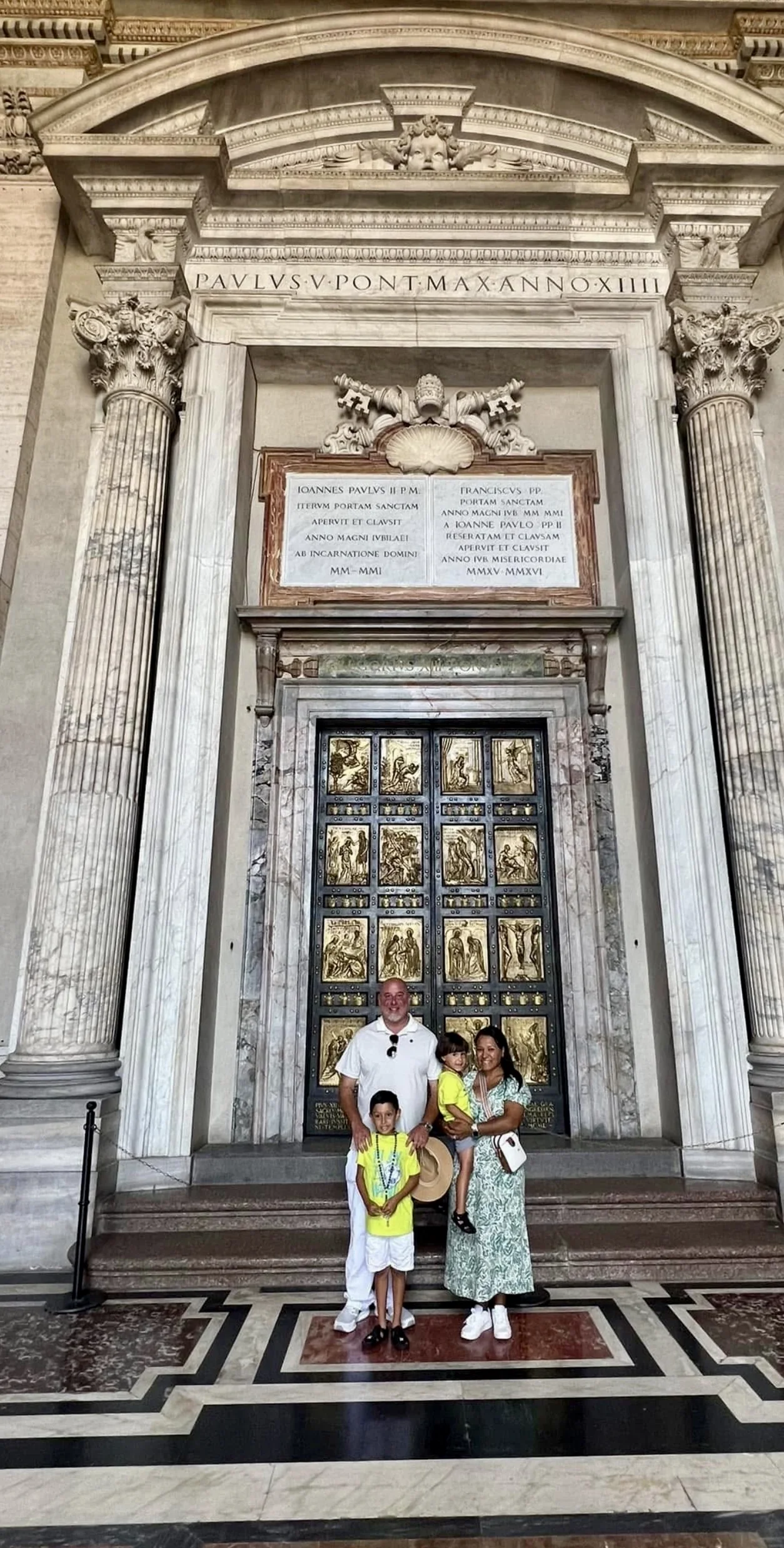 Andrew McGilly and his family beneath the Holy Door of St. Peter's, with the Jubilee inscriptions of John Paul II and Francis above