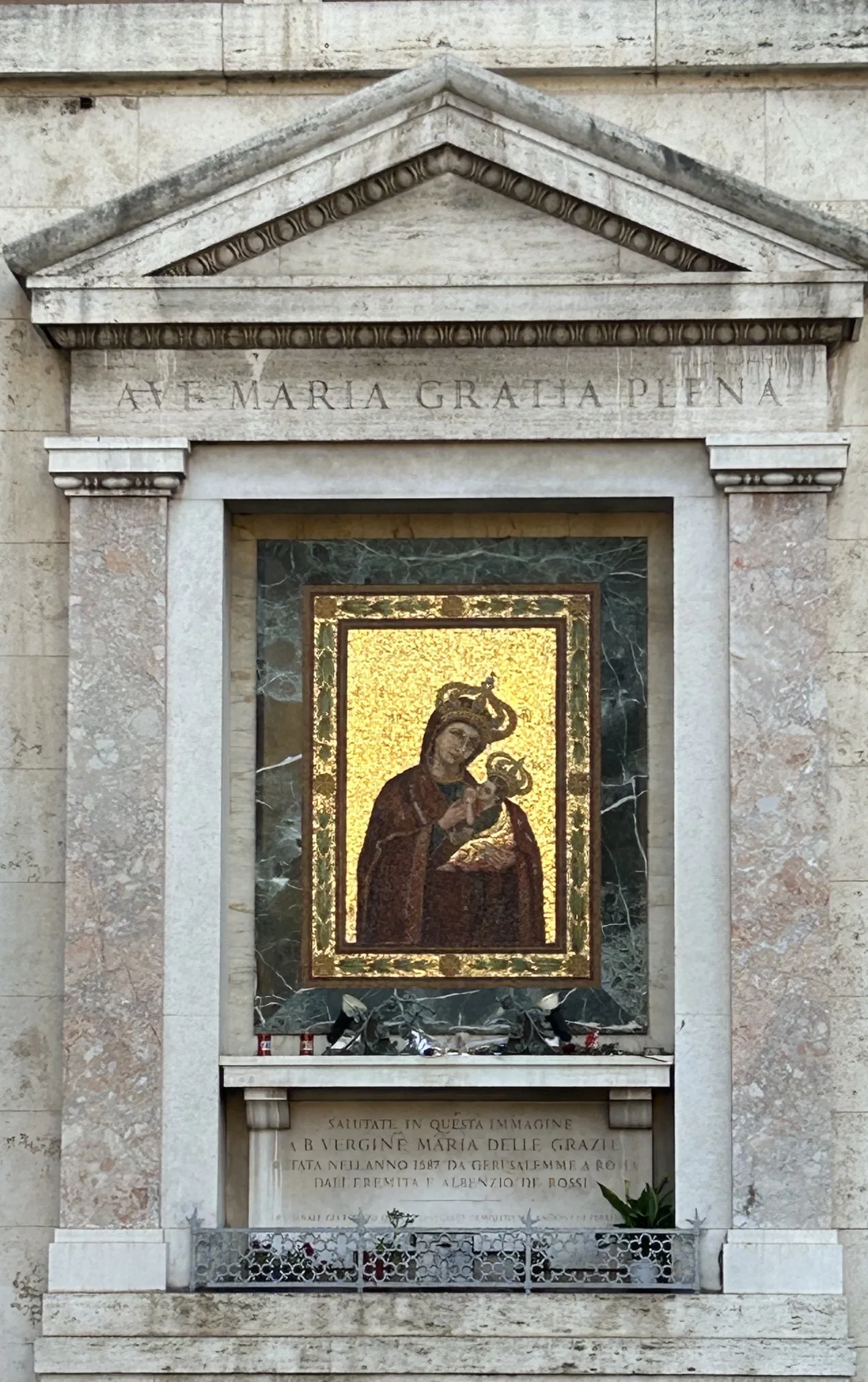 A gold mosaic of the Madonna delle Grazie under a stone pediment reading AVE MARIA GRATIA PLENA, near the Vatican