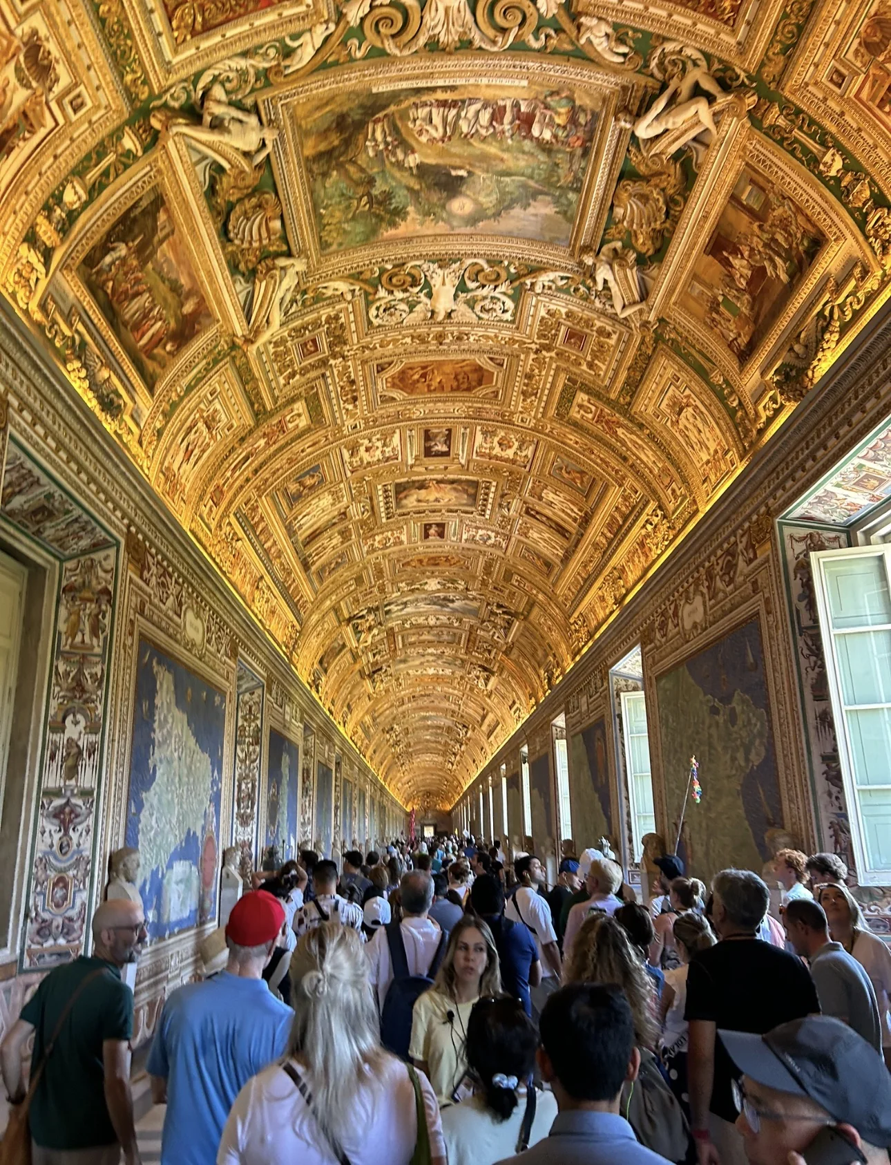 Crowds of visitors in the Gallery of Maps in the Vatican Museums under its gilded ceiling