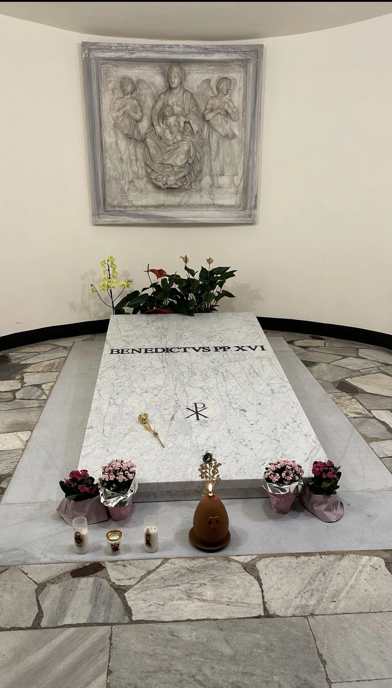 The tomb of Pope Benedict XVI in the Vatican Grottoes, with flowers and candles left by pilgrims